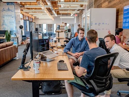 Group of people talking together in workplace