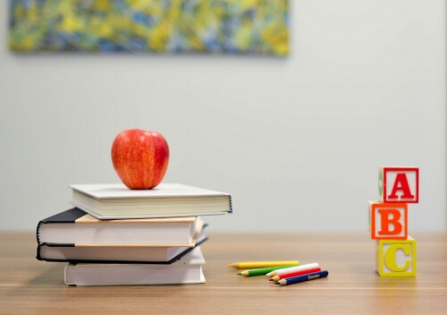 Assorted pencils in a container on a desk in a school